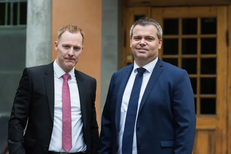 Foto av to menn i dress.