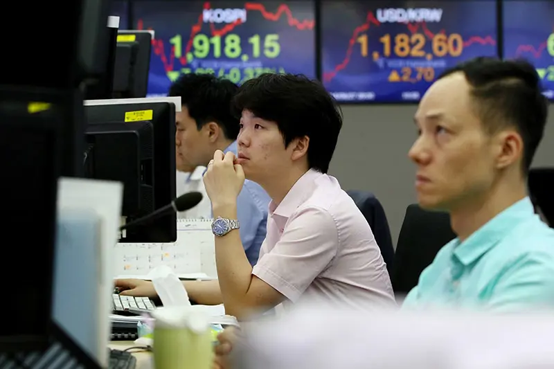 Tre menn sitter ved dataskjermer